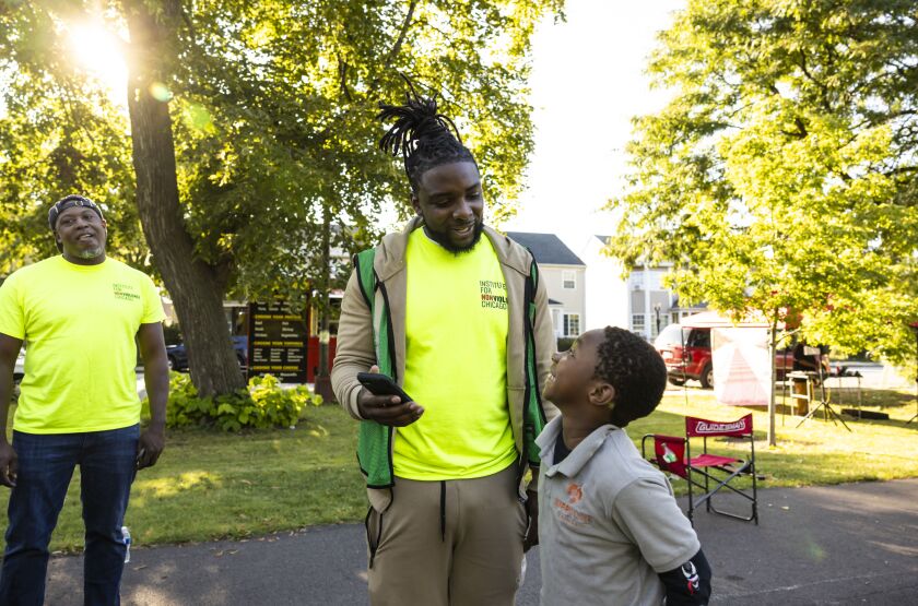 Rayqwan Alexander, 32, an outreach worker at the Institute for Nonviolence Chicago, spends time with kids at an outreach event in West Garfield Park.