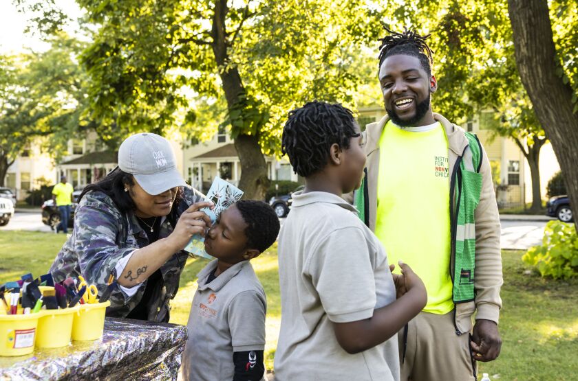 Rayqwan Alexander, 32, an outreach worker at the Institute for Nonviolence Chicago, interacts with kids getting their faces painted at an outreach event in West Garfield Park.