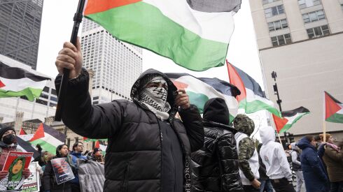 Protesters wave Palestinians flags as they march on the Magnificent Mile on Friday, Nov. 24, 2023.