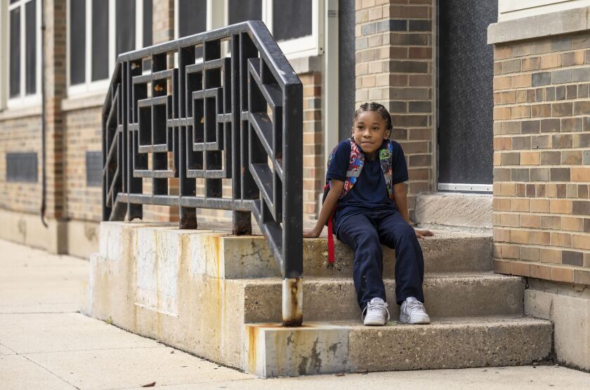 Cornell Moses Jr., 6, sits on the steps outside of Genevieve Melody Public School in West Garfield Park while he waits for his mother.