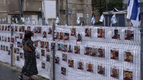 A woman looks at photographs of hostages, mostly Israeli civilians who were abducted during the Oct. 7 Hamas attack on Israel, in Ramat Gan, Israel, on Wednesday.