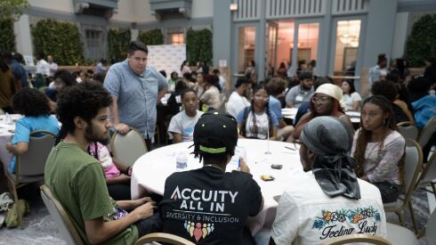 Edwin Ortiz, equity officer in the city’s Housing Department, stands listening during a Youth Budget Roundtable session in the Winter Garden of the Harold Washington Library.