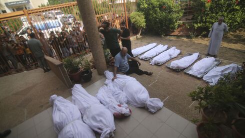 Palestinians gather around the bodies of people killed in Israeli airstrikes in Khan Younis, Gaza Strip, Oct. 11, 2023.