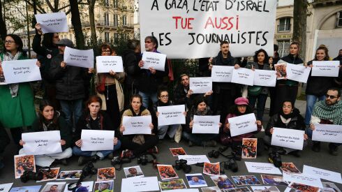 Protesters, holding a banner which reads as “In Gaza, the State of Israel also kills journalists” and displaying the names and photographs of the killed ones, take part in a demonstration to demand an immediate ceasefire in Gaza near Place de la Republique in Paris, on Nov. 11, 2023.