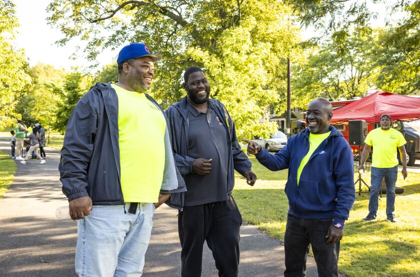 Marcus “Moon” Mitchell, 49,&nbsp;outreach and intervention manager at the Institute for Nonviolence Chicago, engages in conversation with non-profit workers during an outdoor outreach event in West Garfield Park.