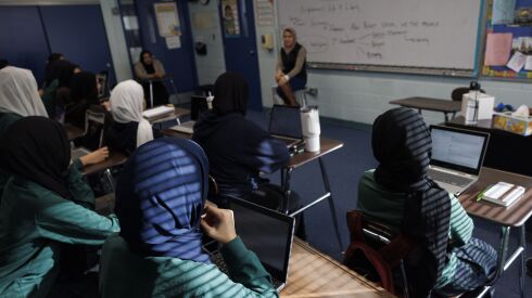 Students wearing hijab head scarves at an Islamic school in Chicago’s southwest suburbs listen to teacher Nadia Ismail.